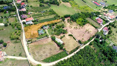 22098 In Cserszegtomaj, a building plot with panorama to the lake Balaton is for sale. It is bordered by a stone wall and a wrought iron gate.